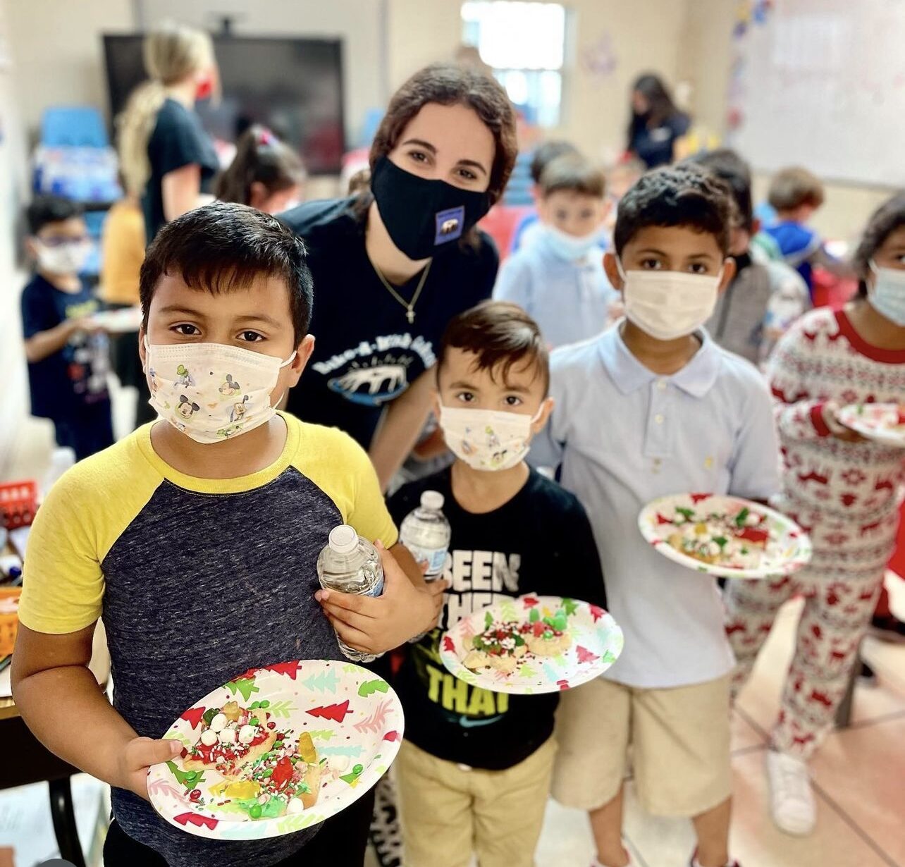Children proudly showing their decorated plates of holiday treats