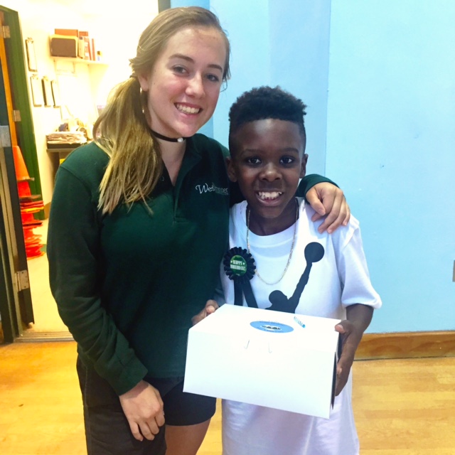 Volunteer presenting a birthday cake to a happy child