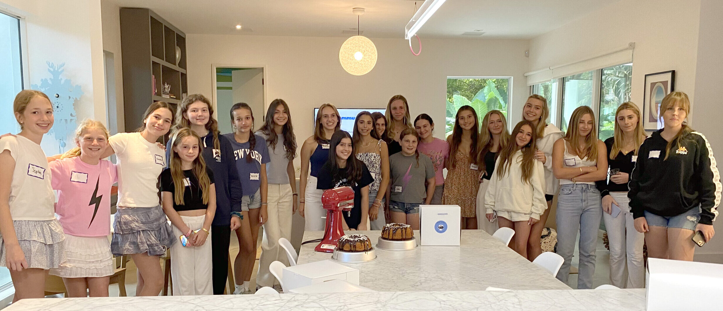 Bake-A-Wish volunteer team in the kitchen with baking equipment and finished cakes
